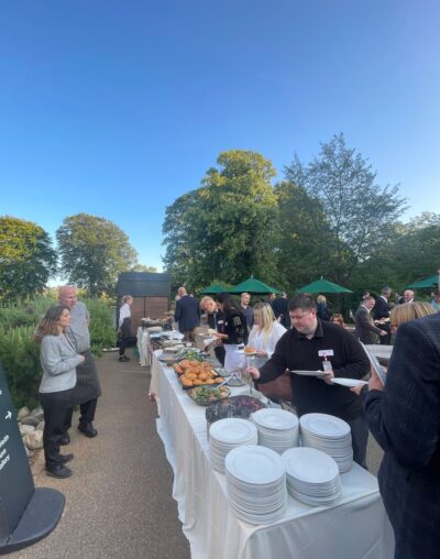 barbeque corporate summer event with people selecting food at outdoor gardens